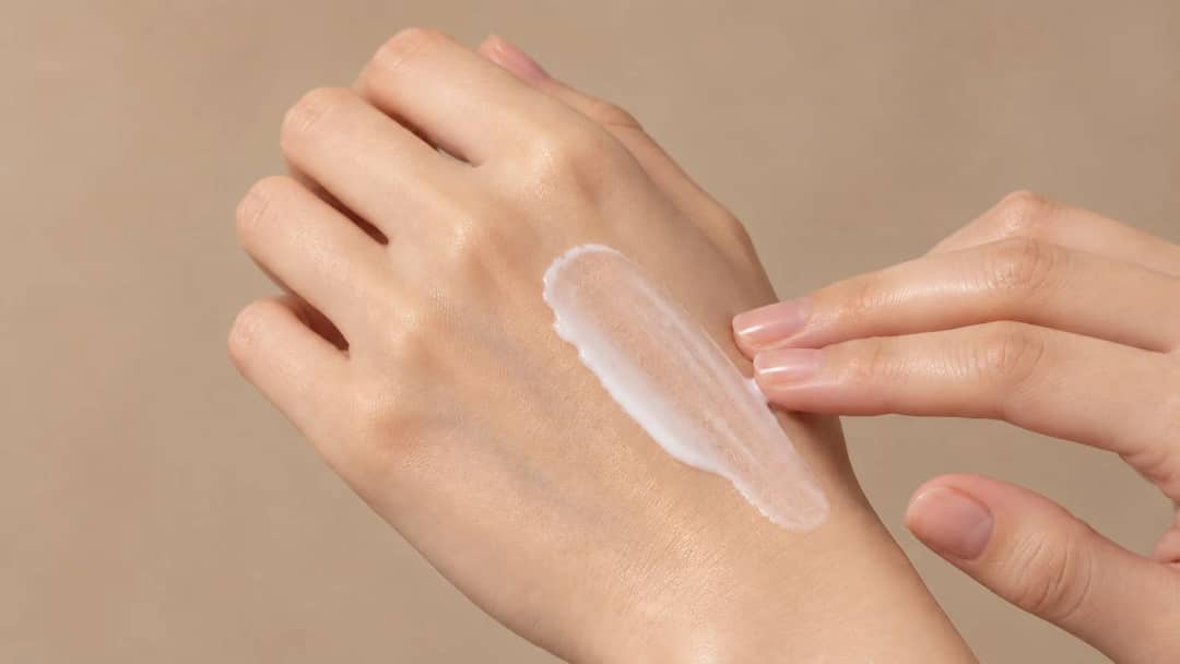 Sunscreen texture swiped on the back of a hand, showing a translucent finish with no white cast